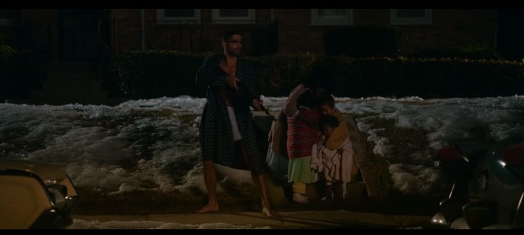 Malcolm X segurando um rifle para proteger sua mulher e filhos