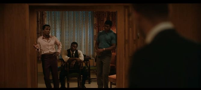 Três homens negros ouvindo Malcolm X